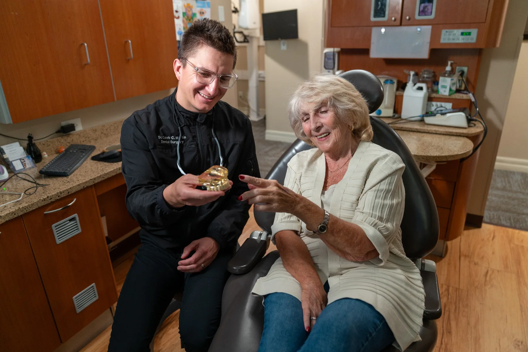 Caleb Martin discussing a dental model with a patient